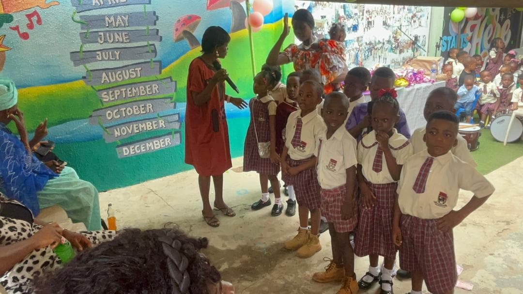 School ceremony with students in cream and burgundy uniforms